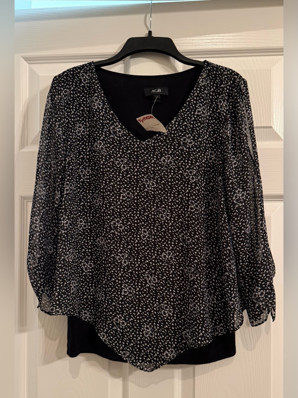 New Women’s AGB Black with white floral flowy top. Size small. New with tag.